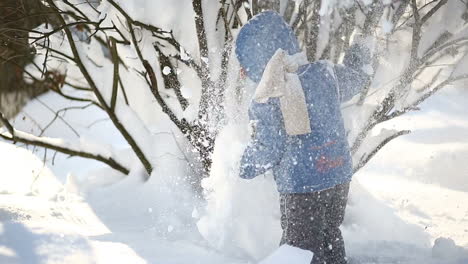 Kid playing in snow. Boy playing outdoors on a snowy winter day