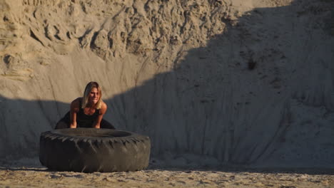 chica en una cantera empujando la rueda en el entrenamiento de crossfit