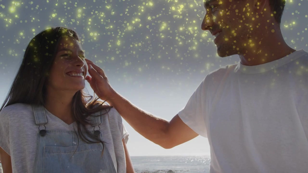 Pareja sonriendo, el hombre acariciando la mejilla de la mujer con cariño, mostrando amor, con destellos sobre sus cabezas, anuncios.