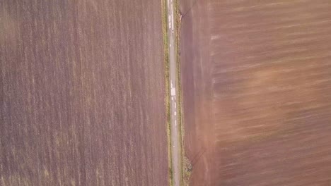 Flying-over-a-road-in-a-rural-area-looking-down-from-a-drone