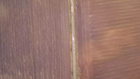 volando sobre una carretera en una zona rural mirando hacia abajo desde un dron