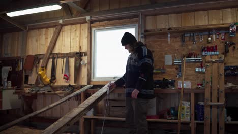 a man is taking measurements of the lumber in indre fosen, trondelag county, norway - static shot