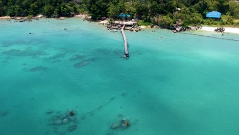 aerial of beautiful turquoise blue sea with old wooden pier koh rong sanloem, cambodia