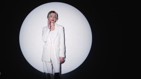 woman in white suit under spotlight