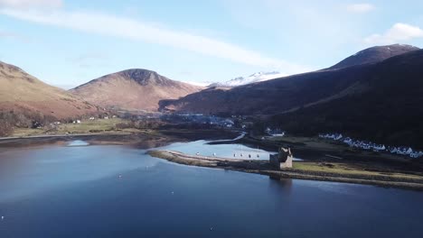 Lochranza-Castle-Dolly-Rückwärts-Mit-Schneebedeckten-Bergen-Und-Umgebungen-Von-Wasser