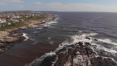 aerial: raise drone at south african coast with small valley in background