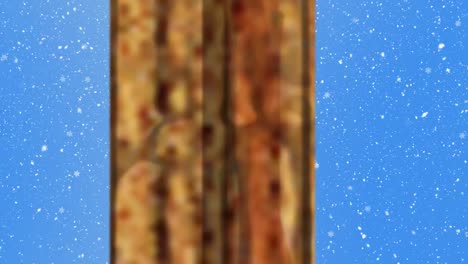 lámpara de navidad, decoraciones colgantes y marco de ventana sobre copos de nieve que caen contra un fondo azul