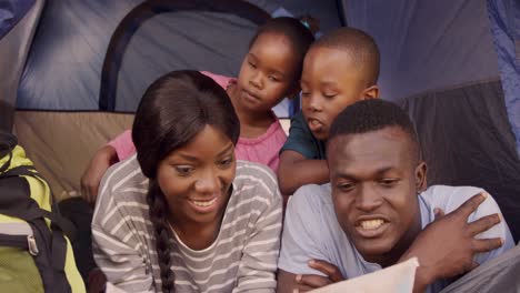 Familia-Sonriente-Mirando-La-Tarjeta-Del-Mapa