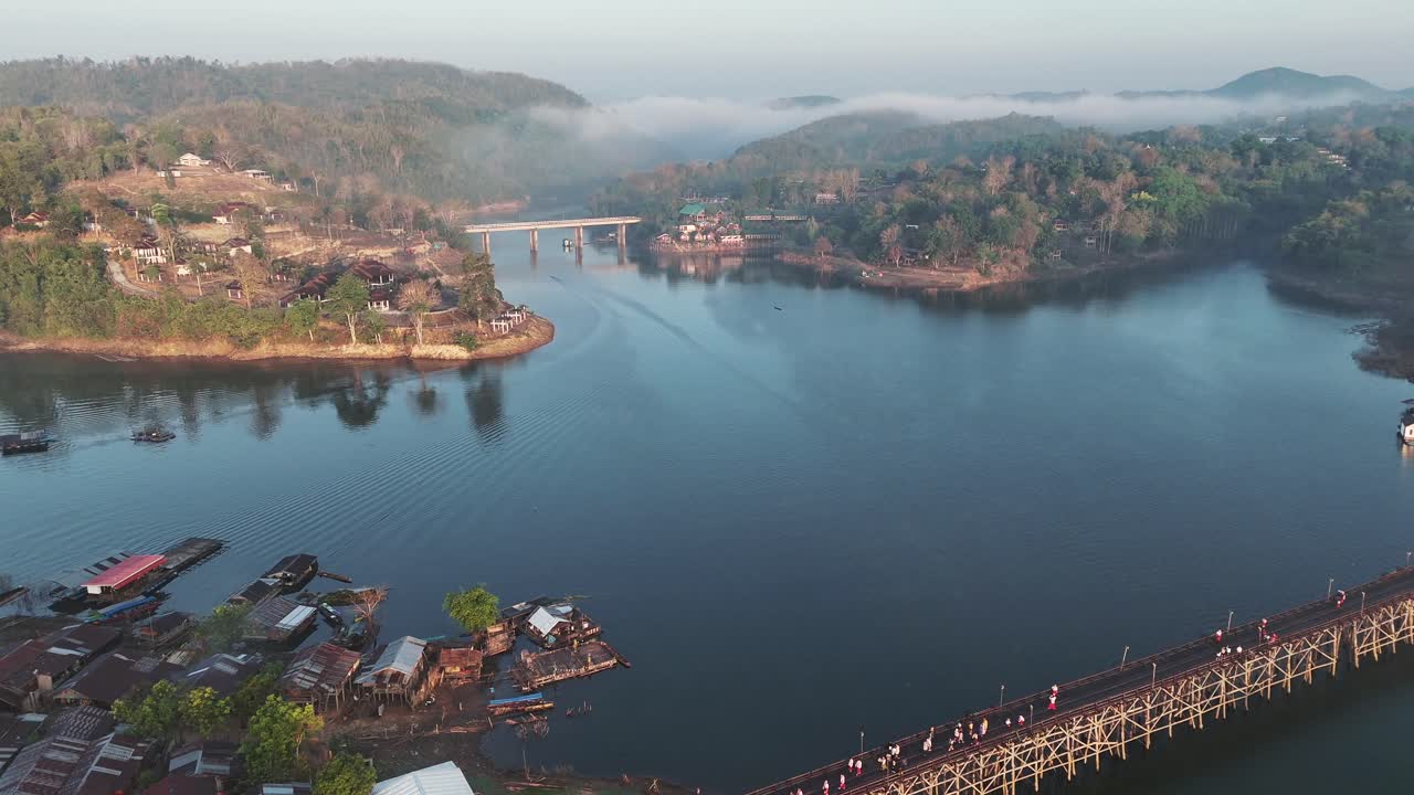 una vista panorámica de la aldea mon, con su río, puentes y puertos, capturando el encanto escénico y la vibrante actividad de la comunidad