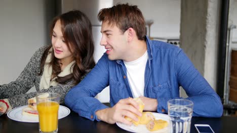 couple using digital tablet while having breakfast