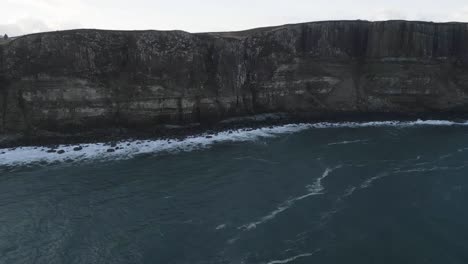 Kilt-rock-sea-cliffs-in-skye,-scotland,-with-waves-crashing,-aerial-view