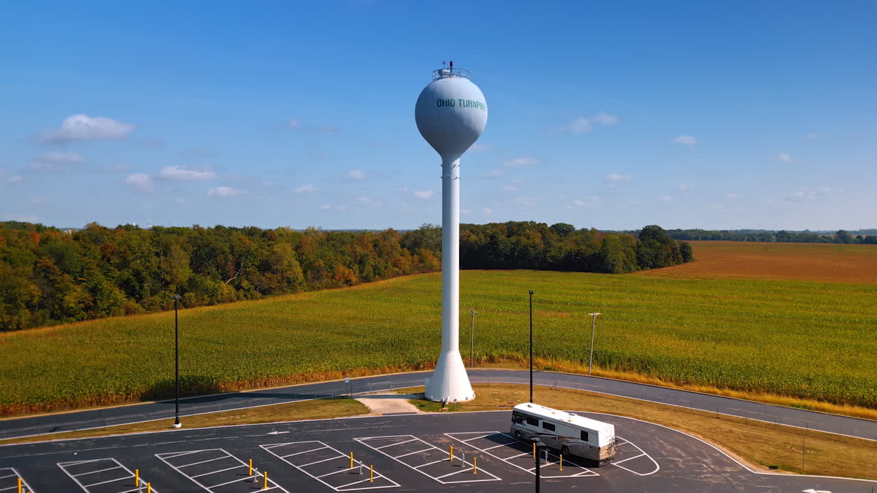 Chicago, USA, 29 June 2025: Aerial drone view of the Ohio Turnpike water tower and empty RV parking lot surrounded by green fields and forest