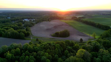 Amanecer-Sobre-Un-Hermoso-Pueblo,-Bosques-Y-Campos-Bañados-Por-Los-Rayos-Del-Sol-Naciente