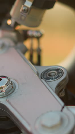 A close-up of a person s hand as they insert a key into the ignition of a motorcycle