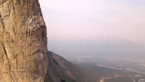 Aerial-4K-footage-of-a-drone-flying-close-to-Rocky-Mountain-range-during-wildfire-smoke-in-Canada