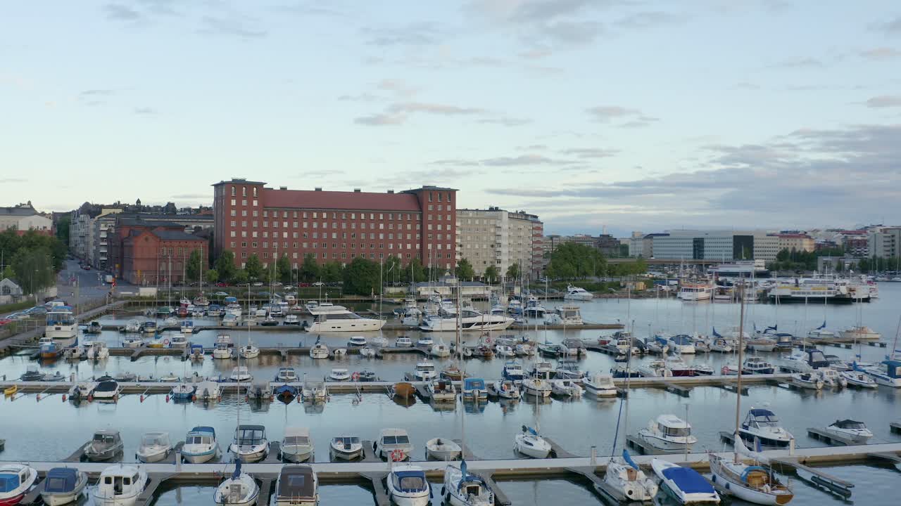 panorámica aérea lenta de barcos en un muelle a lo largo de la costa de helsinki, finlandia
