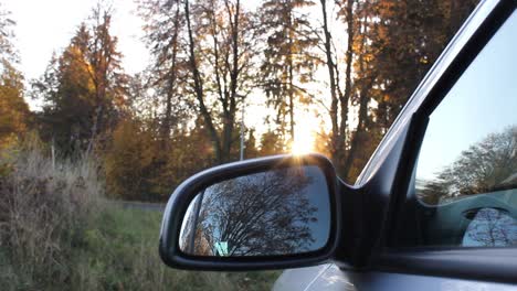 Car-in-woodland-with-sunset-peaking