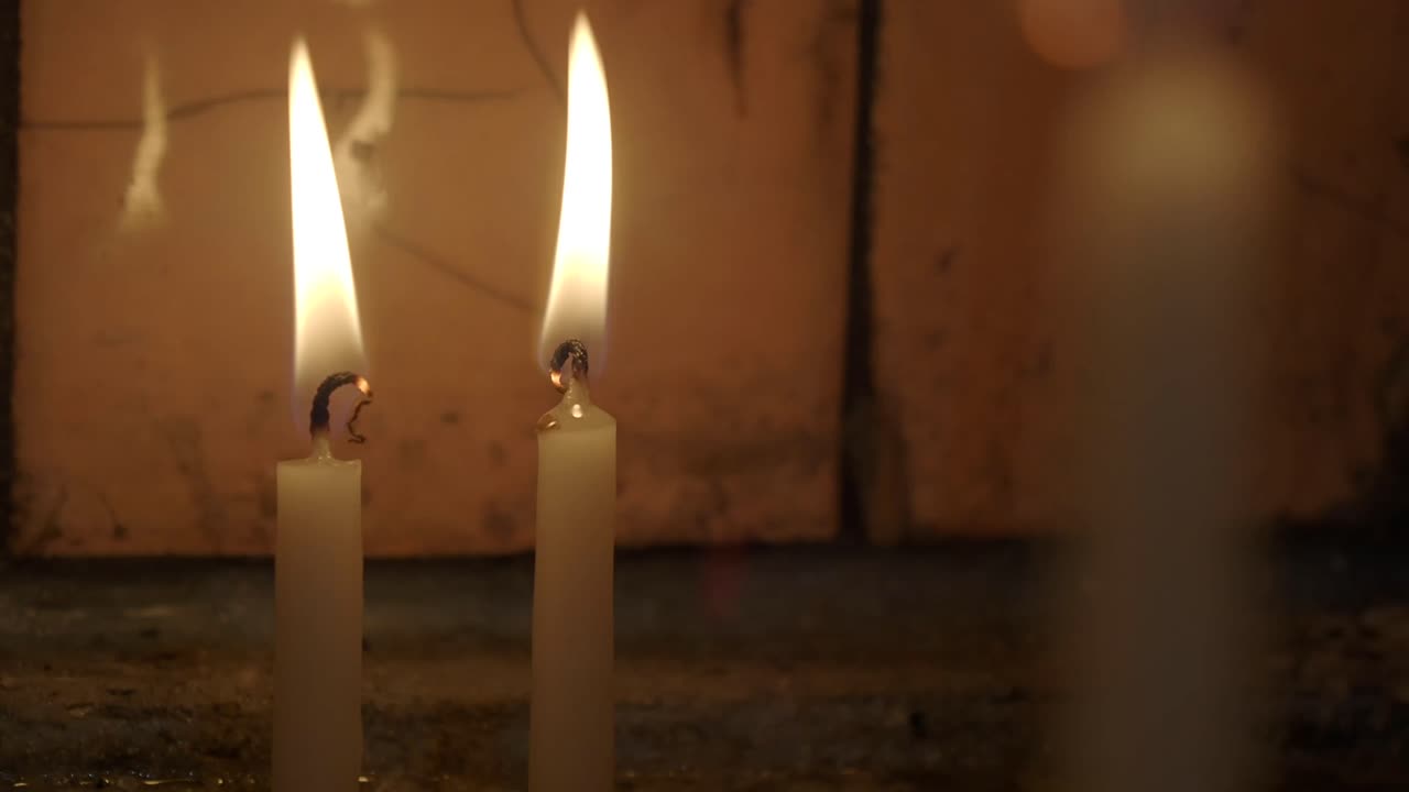 Il caldo bagliore di due candele accese nel buio