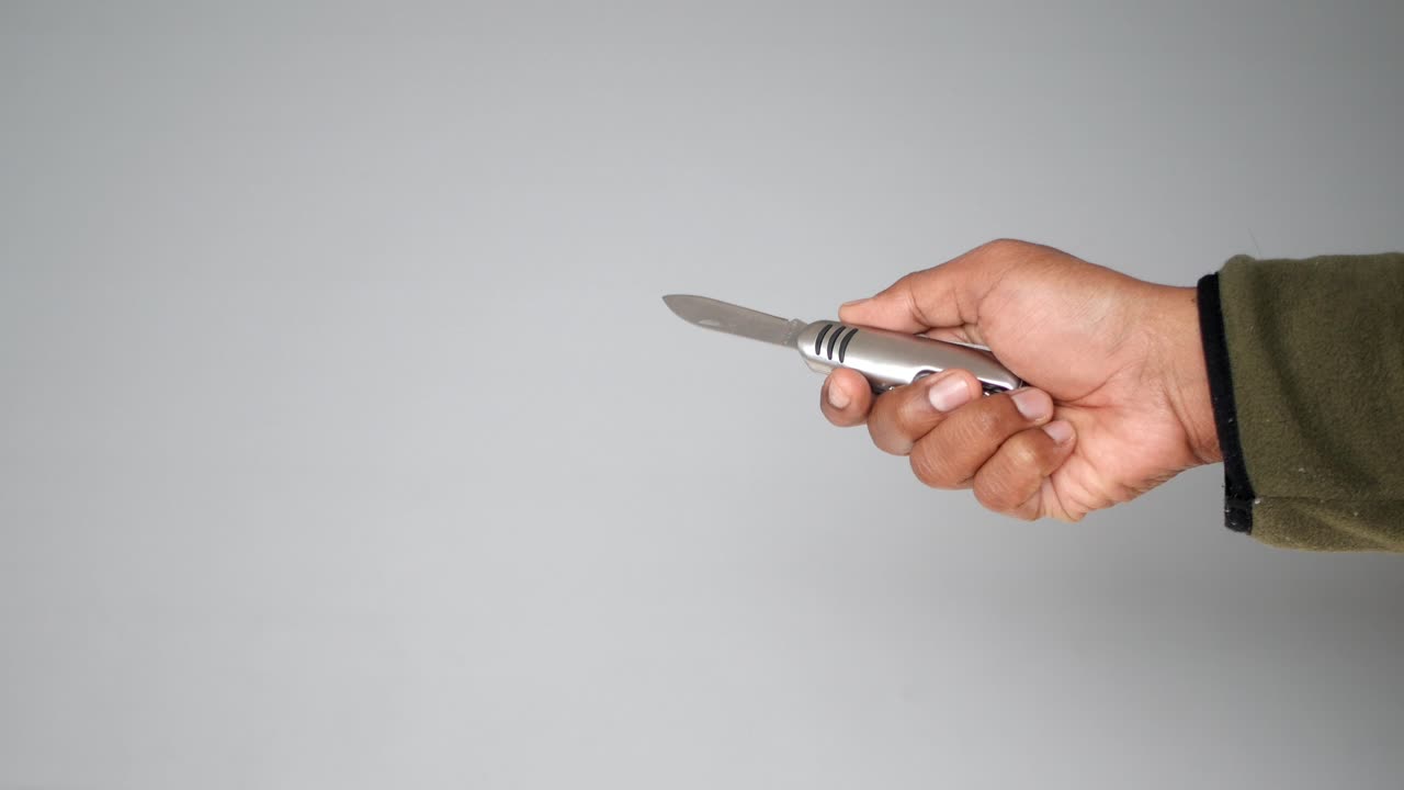Hand holding and manipulating a multi-tool knife