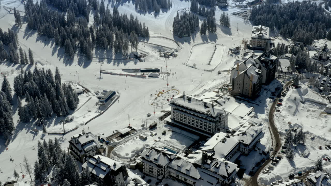 Aerial View of a Snowy Ski Resort with Hotels and Slopes