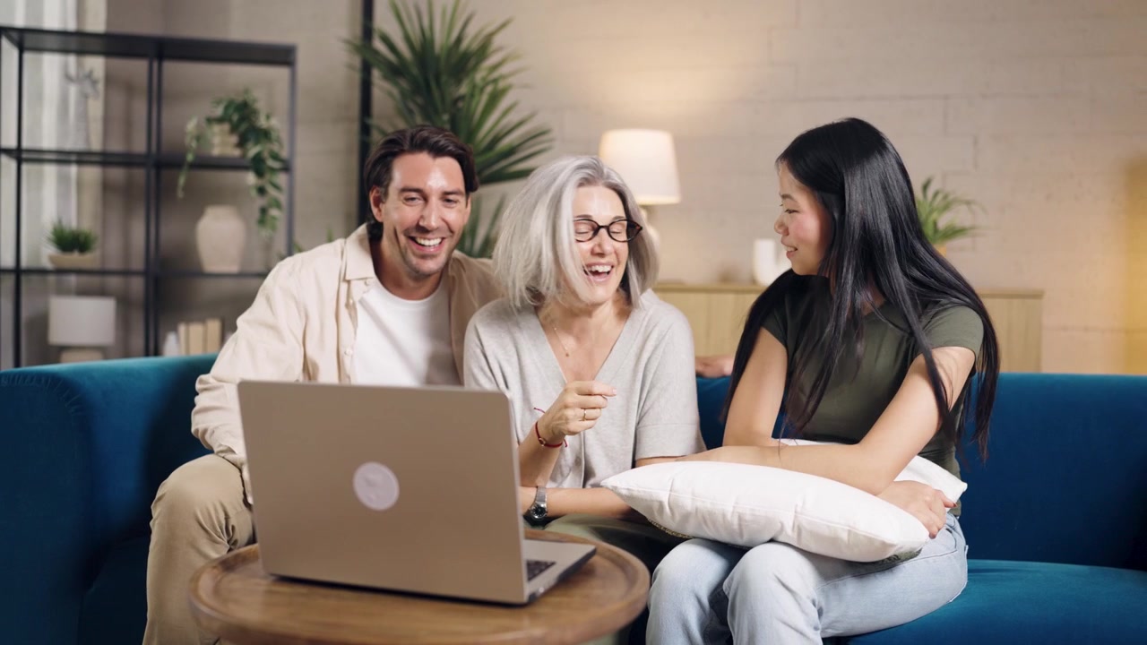 Familia diversa haciendo una videollamada en un portátil en la sala de estar