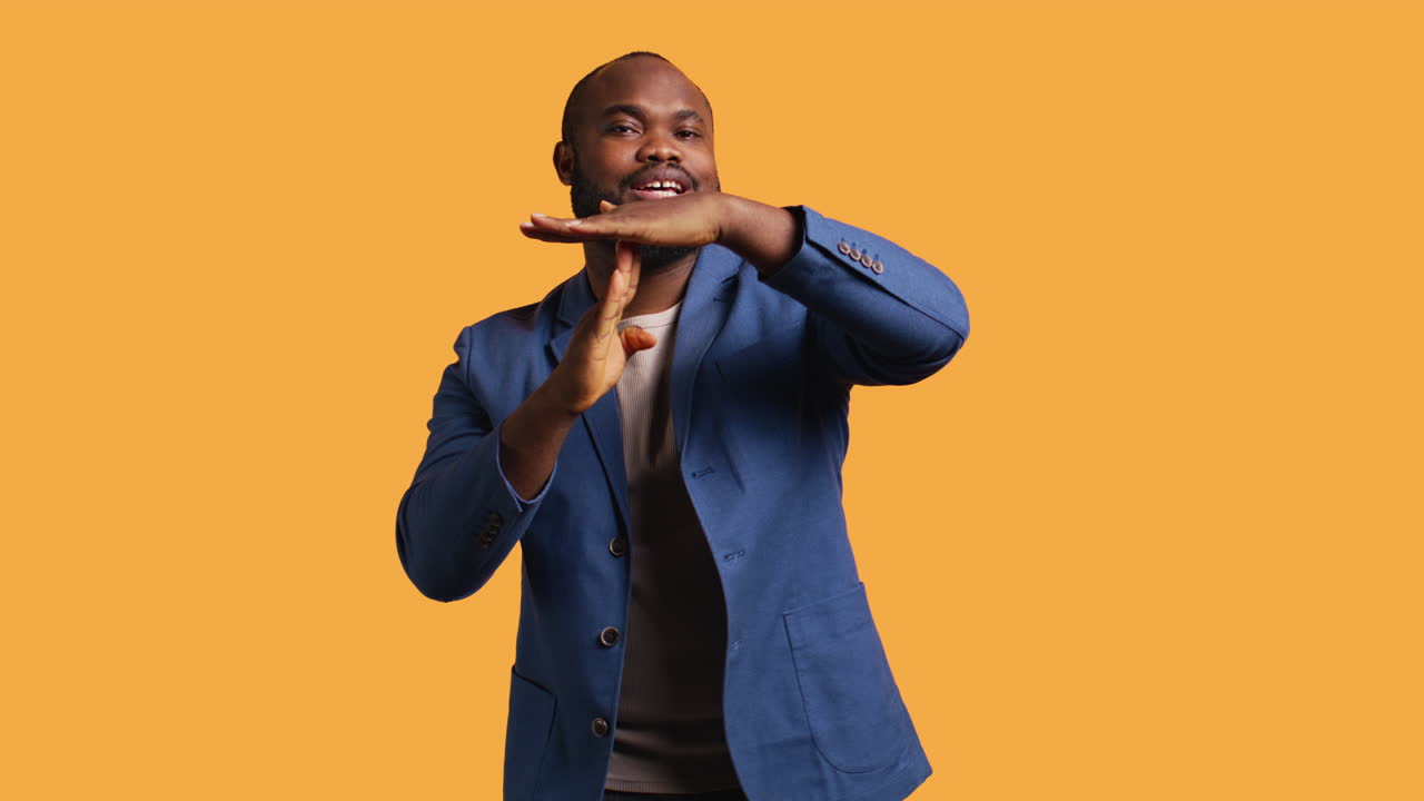 Cheerful man asking for timeout, halting activities, studio background