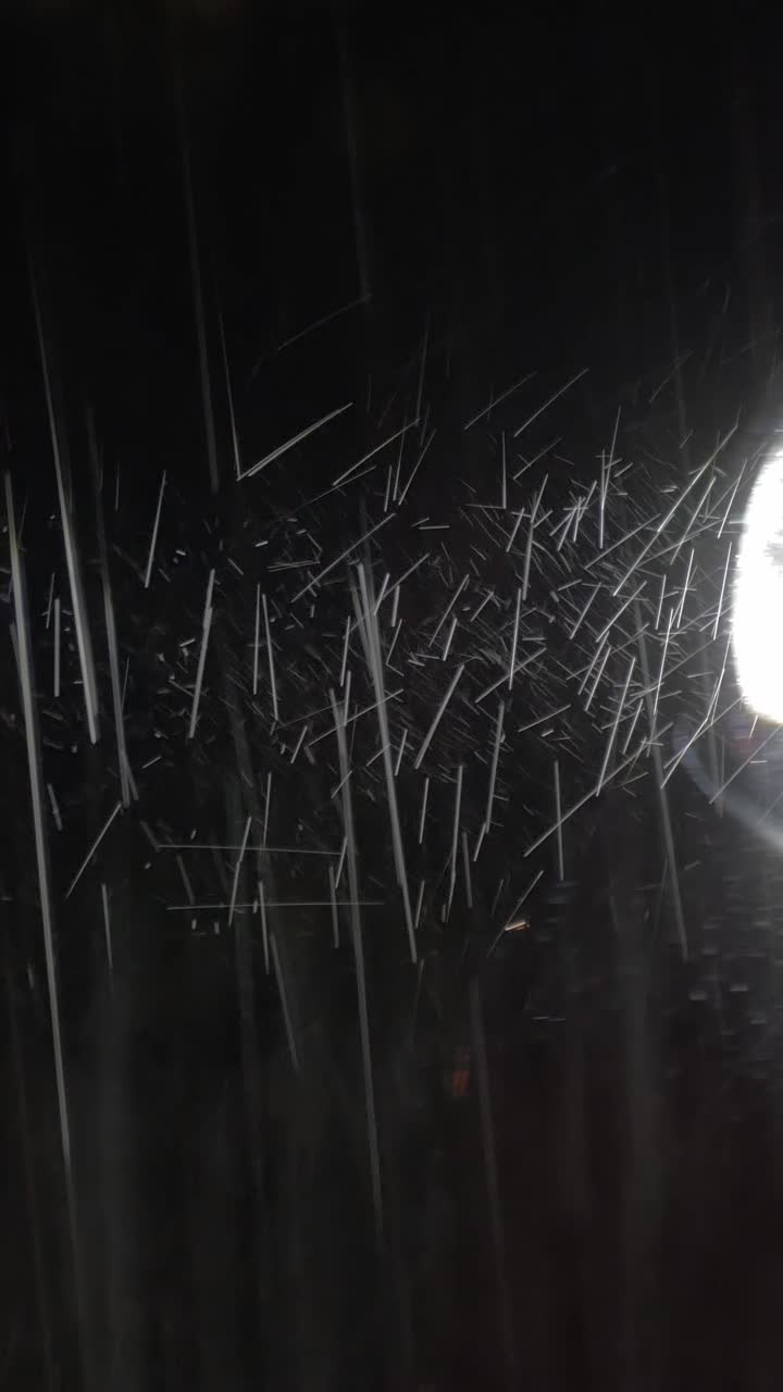 Heavy Rain Falling at Night Illuminated by Car Headlight