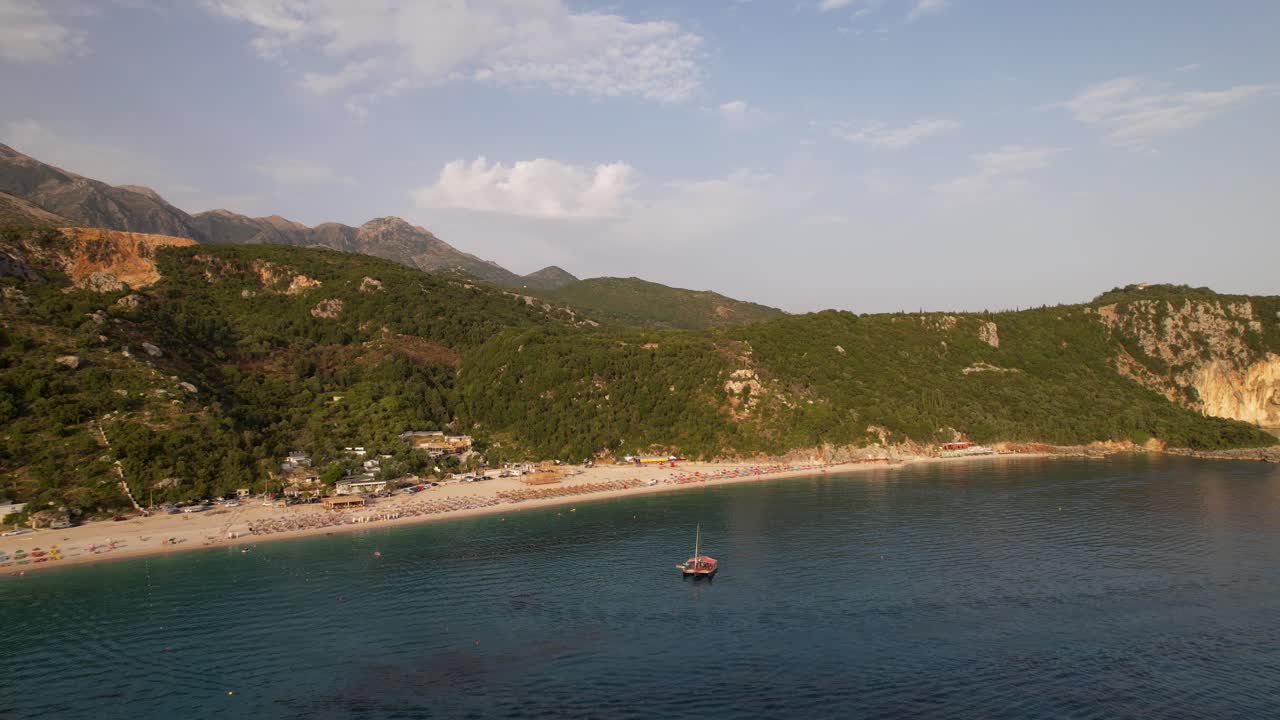 Idyllic beach on a quiet place surrounded by green hills with umbrellas and vacation resorts in Albania