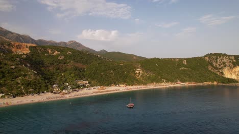 idyllic beach on a quiet place surrounded by green hills with umbrellas and vacation resorts in albania