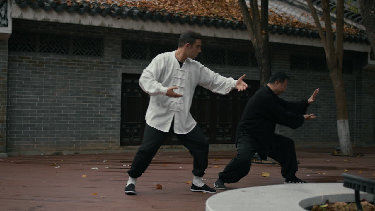 Men Practicing Martial Arts Outdoors in Traditional Setting