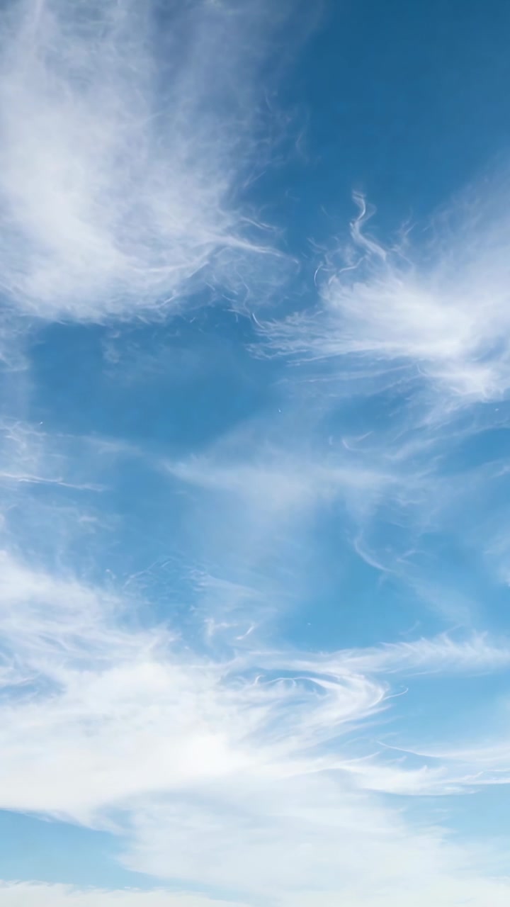 Video verticale: Cielo azzurro mutevole che mostra nuvole cirri sospinte da venti forti, con striature che si riformano
