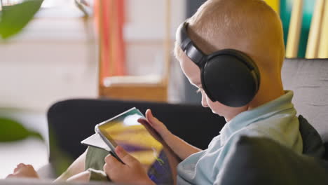 niño usando tableta con auriculares