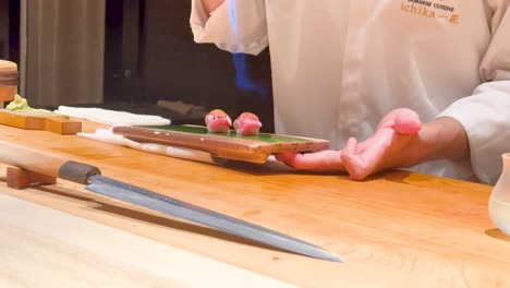 chef uses torch to prepare sushi dish