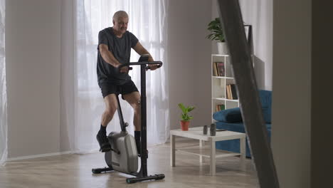 estilo de vida saludable y mantenerse en forma en la mediana edad persona está entrenando con bicicleta estacionaria en el hogar ejercicios de cardio en el interior