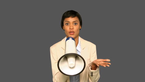 una mujer de negocios concentrada hablando por megáfono.