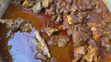 close rotating shot of delicious mutton curry along with gravy on display in an indian function