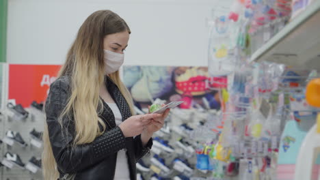 mujer comprando productos para bebés con una máscara