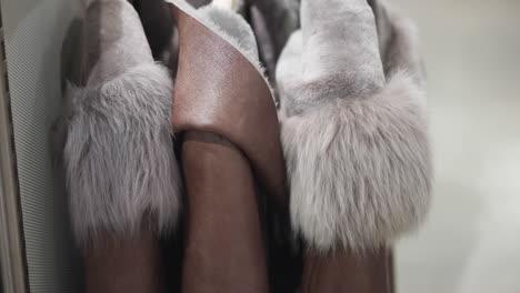 close-up of luxurious brown jackets with soft, plush fur collars, showcasing detailed textures and elegant craftsmanship in modern outerwear in a well lit store