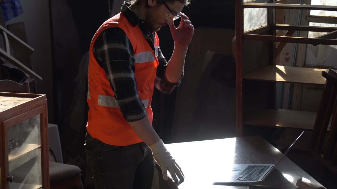 carpintero infeliz hombre decepcionado con la computadora portátil dueño de un negocio cansado trabajador de madera en el taller