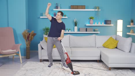 hombre gracioso limpiando la casa, bailando y divirtiéndose.
