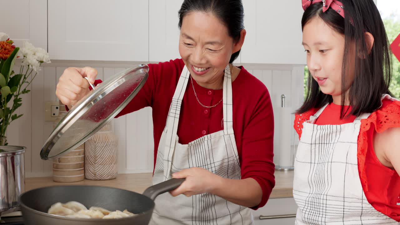 Asian family, mom and kid cooking dumplings in pan