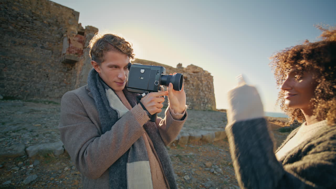 Positive girl posing photographer at evening beach closeup. Couple filming love
