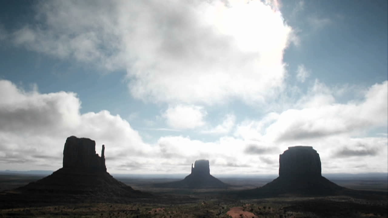 흰 구름은 모뉴먼트 밸리 유타의 암석 위로 빠르게 움직입니다.