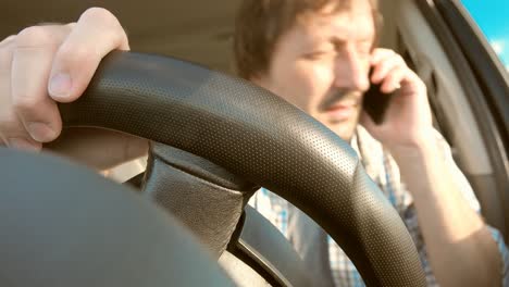 man driving car and talking on mobile phone