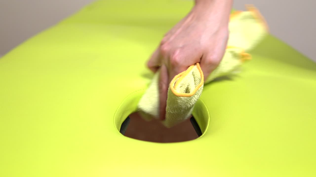 물리치료사는 환자와 마사지를 할 수 있는 재료를 준비하는 마사지 테이블을 청소합니다.