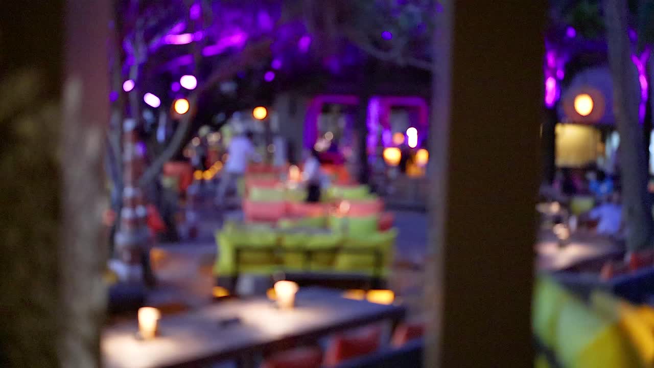 vista borrosa de la vibrante escena del restaurante por la noche en phuket