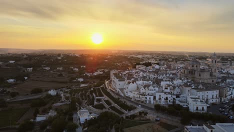 Vista-Panorámica-Aérea-Del-Paisaje-Sobre-Casas-De-Pueblo-De-Locorotondo-Y-Viñedos-En-Terraza,-Ciudad-Tradicional-Italiana-En-La-Cima-De-Una-Colina,-Al-Amanecer.