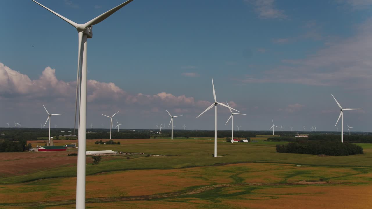 Wind Turbines Spinning in the Wind with a Scenic Aerial Shot Over Farmland