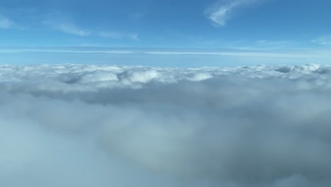 aerial view from a cockpit surfing clouds with a blue skay and day light