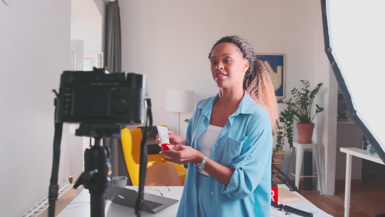 Young african american woman cosmetologist is filming advertisement for cream